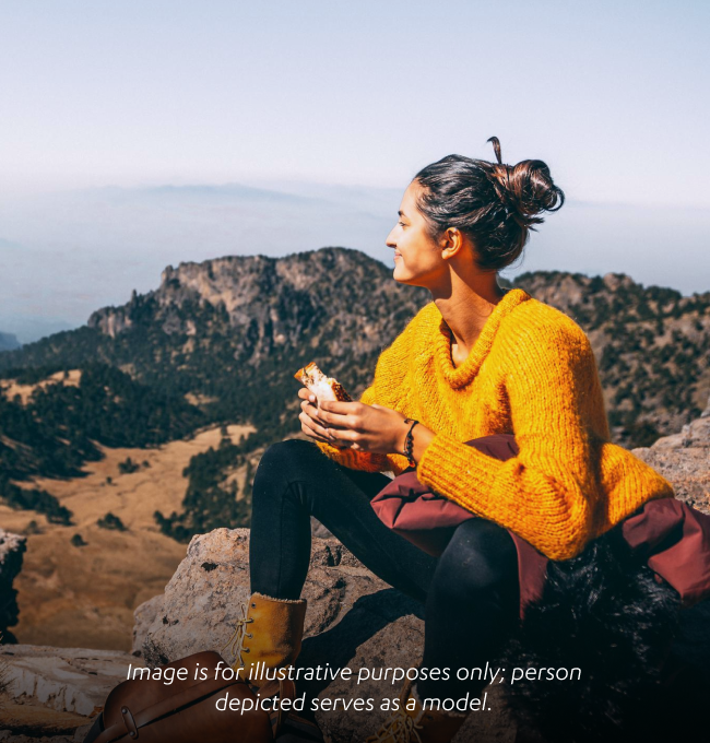 Woman enjoying the mountains while eating a sandwich