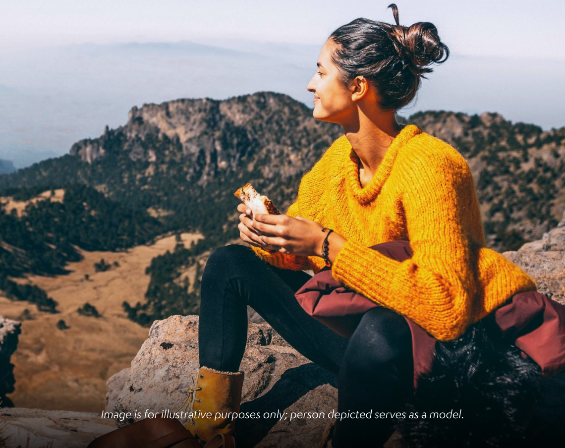 Woman enjoying the mountains while eating a sandwich